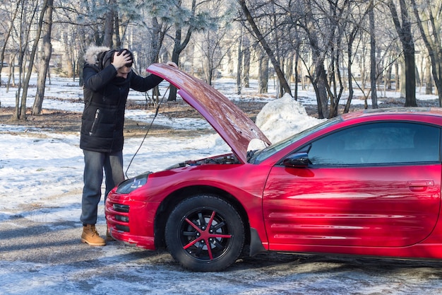 Homme en difficulté avec sa voiture de sport cassée Il a peur que ses mains soient sur sa tête