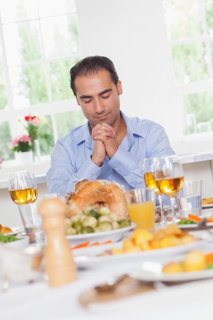 Homme disant grâce avant le dîner