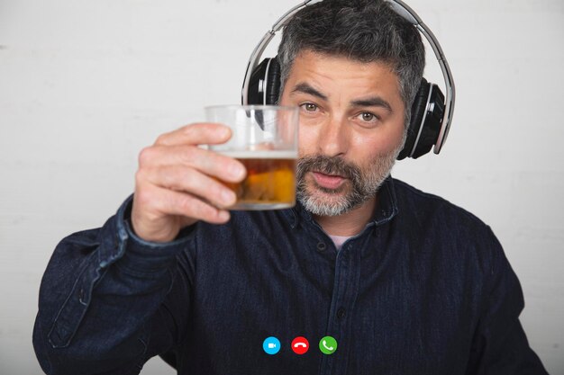 Un homme discutant sur un appel vidéo, une personne partageant un verre de bière sur une plateforme technologique pendant la quarantaine