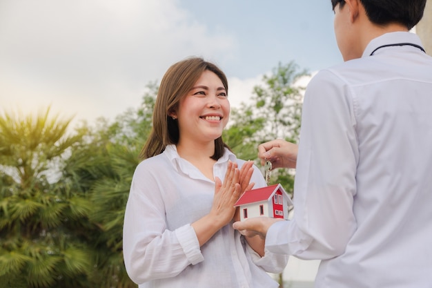 Homme donnant la clé de la maison aux femmes concept de famille heureuse couple amour entreprise familiale location vente investissement d'assurance