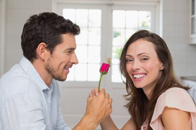 Homme donnant une femme heureuse une rose