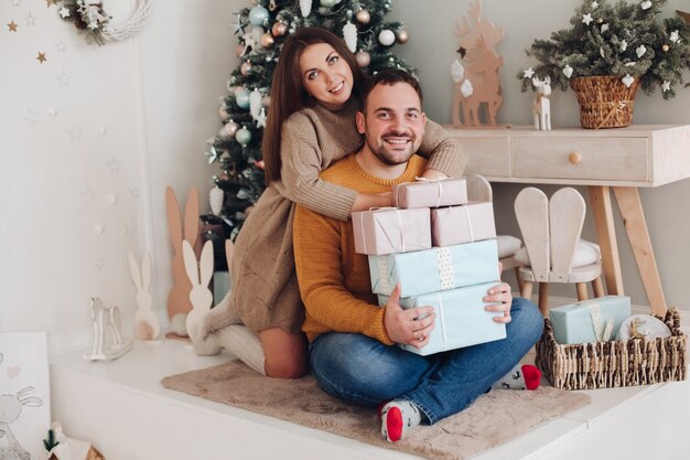 L'homme donne beaucoup de cadeaux de Noël à sa petite amie la veille de Noël