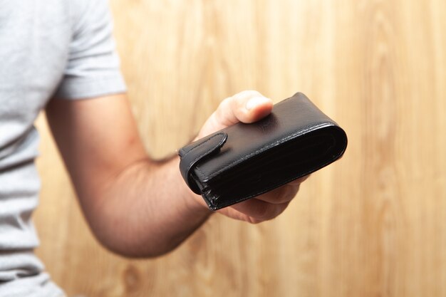 Photo un homme donne un portefeuille sur un fond en bois