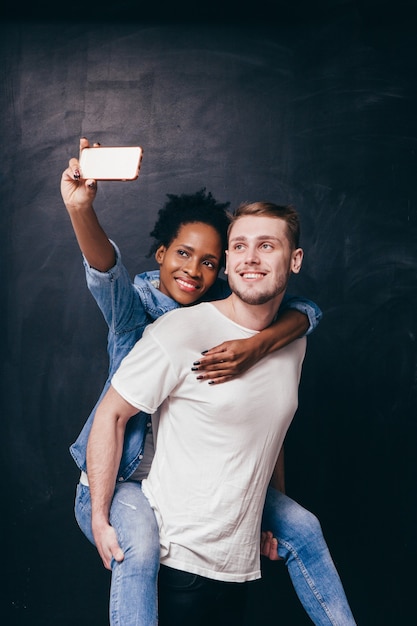 L'homme donne un tour de ferroutage à une femme, un couple selfie sur smartphone