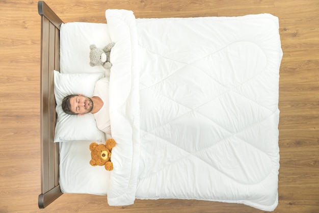 L'homme dort avec une peluche. vue d'en-haut