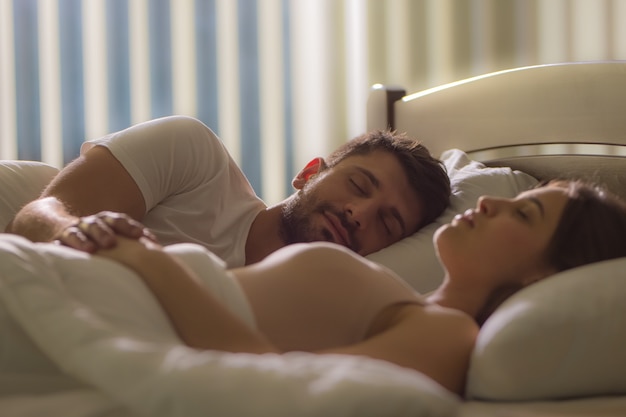 L'homme dort près de la femme dans le lit