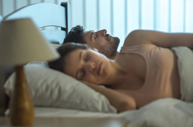 L'homme dort près de la femme dans le lit