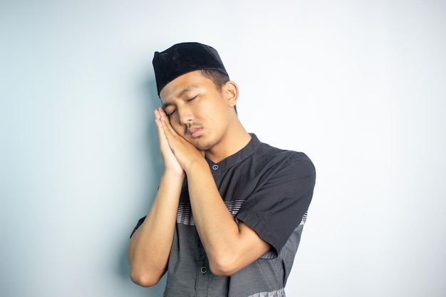 Photo un homme dort les yeux fermés et les mains jointes, et le mot sommeil est sur le côté de la tête.