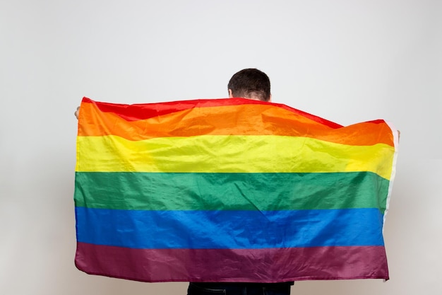 Homme de dos avec un drapeau gay dessus