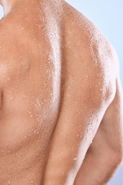 Homme dos et gouttes d'eau pour la douche sur fond d'hygiène de soins de la peau et de dermatologie saine Gros plan derrière le torse fort corps humain masculin et humide avec nettoyage d'anatomie musculaire et bien-être en studio