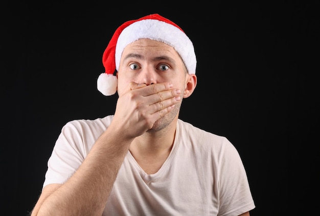 Homme drôle dans un bonnet de noel sur fond noir