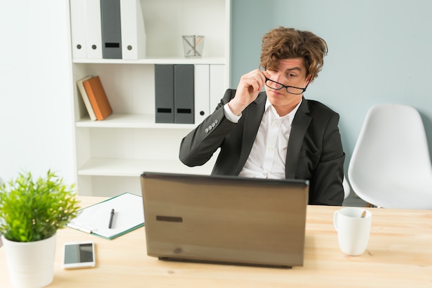 homme drôle fatigué après avoir travaillé sur ordinateur au bureau