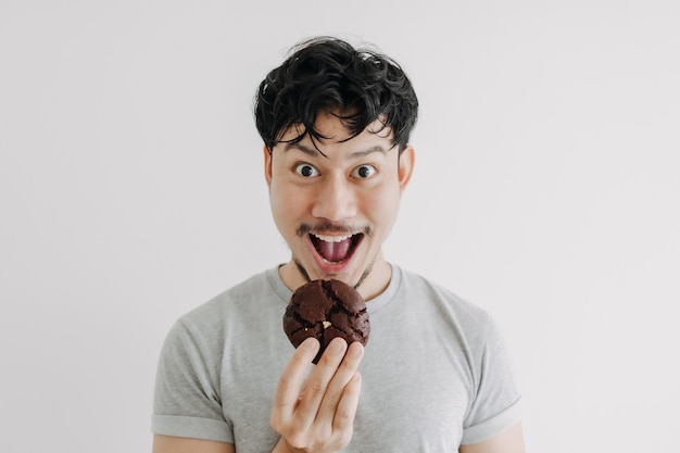 L'homme drôle de visage mange des biscuits au chocolat isolé sur fond blanc