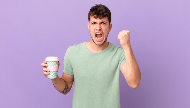 homme avec du café criant agressivement avec une expression de colère ou avec les poings serrés célébrant le succès