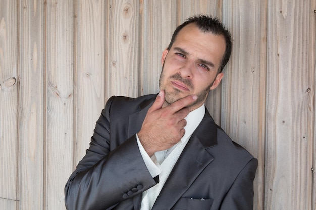 Homme avec du charme avec une chemise sous le fond en bois