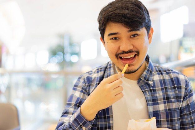 L'homme du Moyen-Orient mordre la chips de pomme de terre pour manger au brunch repas au restaurant avec bonheur dans se détendre