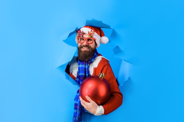 L'homme du père noël tient une grosse boule de noël vacances d'hiver nouvel an vente à prix réduit ventes de noël