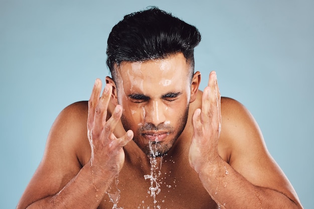 Homme eau et mains dans le lavage du visage pour les soins de la peau hygiène propre fraîche ou toilettage sur fond de studio Jeune mannequin en beauté bien-être et lavage nettoyage ou nettoyage pour le traitement du visage