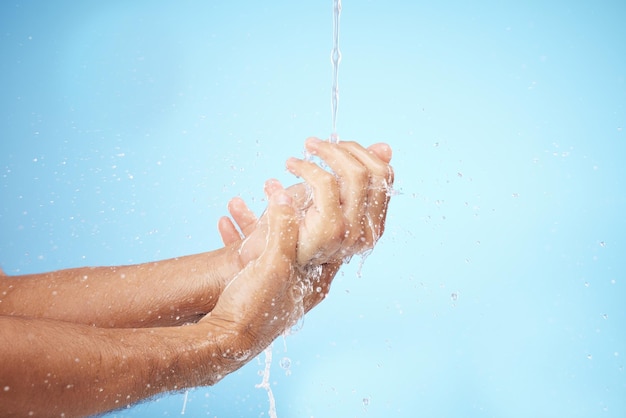 Homme eau ou se laver les mains sur fond bleu pour l'entretien de l'hygiène corporelle soins de santé bien-être ou soins de la peau routine de toilettage Modèle éclaboussures d'eau ou douche courante pour nettoyer les bactéries ou prendre soin de soi