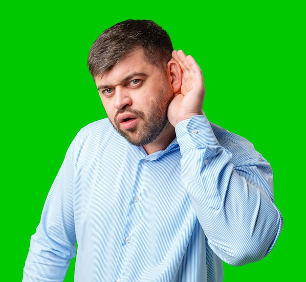 Un homme écoutant attentivement avec une expression surprise dans un fond vert vif