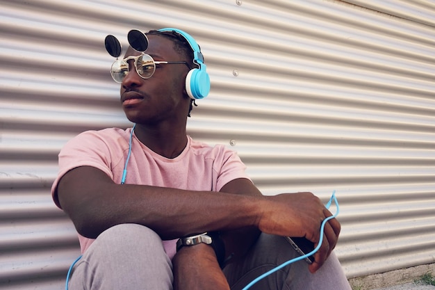 Un homme écoutant de la musique assis contre l'obturateur