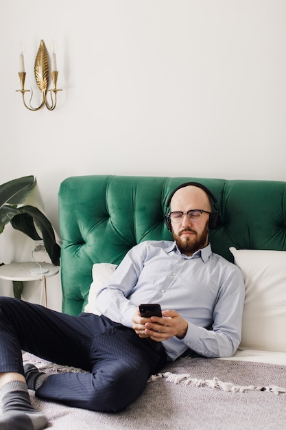 Homme écoutant de la musique sur des écouteurs dans le salon