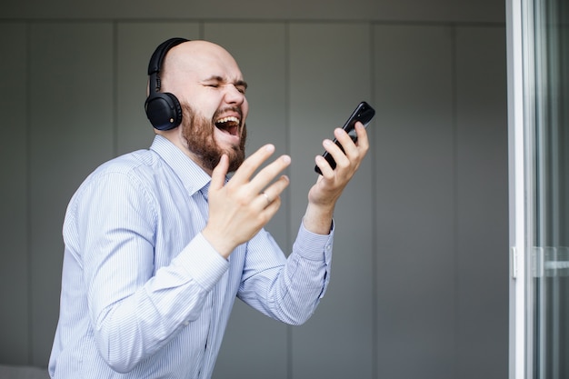 Homme écoutant de la musique sur des écouteurs dans le salon