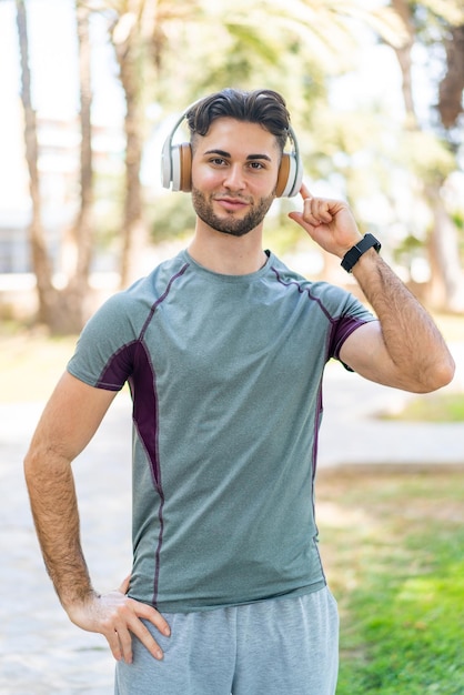 Homme écoutant de la musique avec des écouteurs à l'extérieur