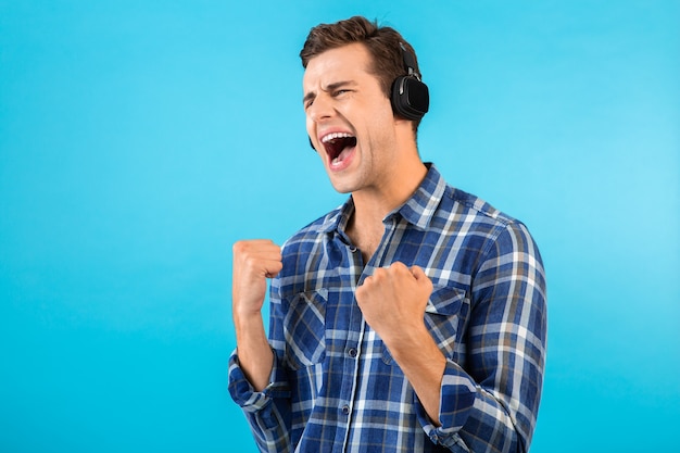 homme écoutant de la musique sur des écouteurs sans fil s'amusant sur bleu