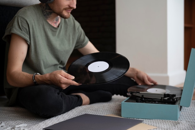 Homme écoutant de la musique à partir d'un disque vinyle