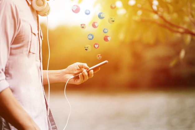 Un homme écoutant de la musique à partir d'un smartphone avec fond de jardin