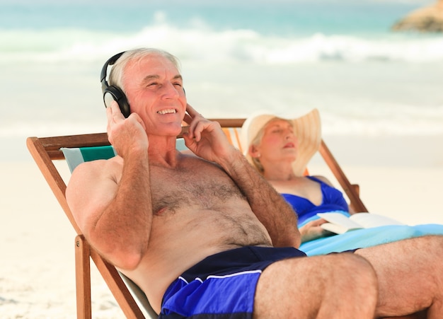 Homme écoutant de la musique pendant que sa femme dort