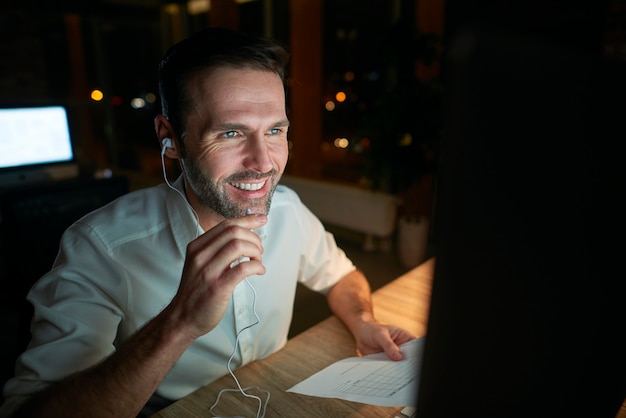 Homme écoutant de la musique et travaillant tard dans son bureau