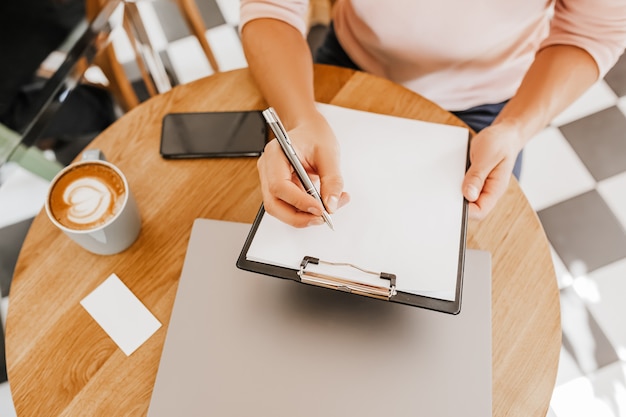 L'homme écrit des informations commerciales dans un ordinateur portable au lieu de travail au bureau avec ordinateur portable