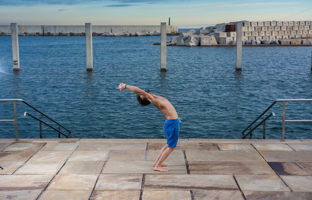 Homme effectuant des exercices de yoga avancés et des étirements.