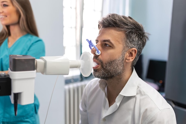 Homme effectuant un test de la fonction pulmonaire et une spirométrie à l'aide d'un spiromètre à la clinique médicale Spirométrie des poumons