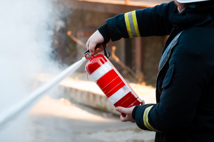 Photo un homme effectue des exercices avec un extincteur. concept d'extinction d'incendie. incident d'urgence incendie