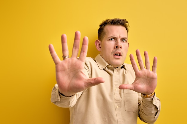 Homme effrayé peur de quelque chose qu'il a vu, isolé sur jaune