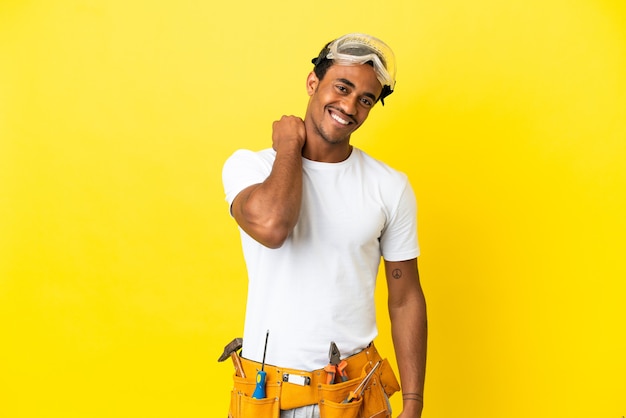 Homme électricien afro-américain sur un mur jaune isolé en riant