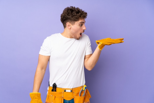 Homme électricien sur fond violet isolé