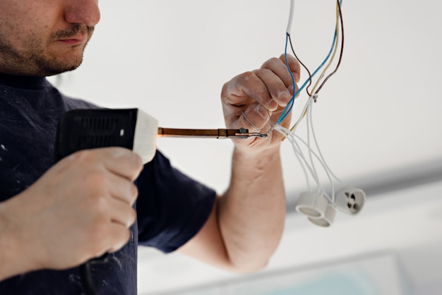 Homme électricien réparant la lumière