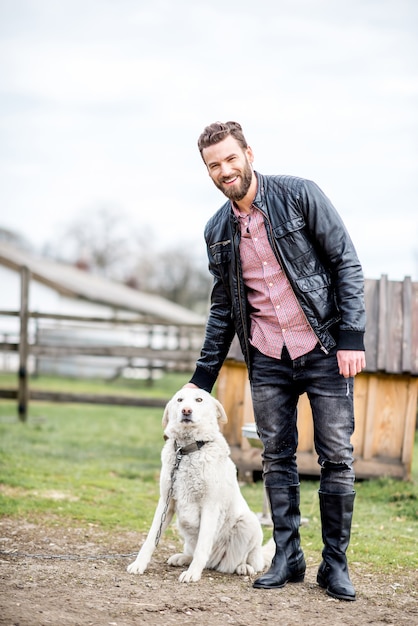 Homme élégant avec chien à l'extérieur à la maison