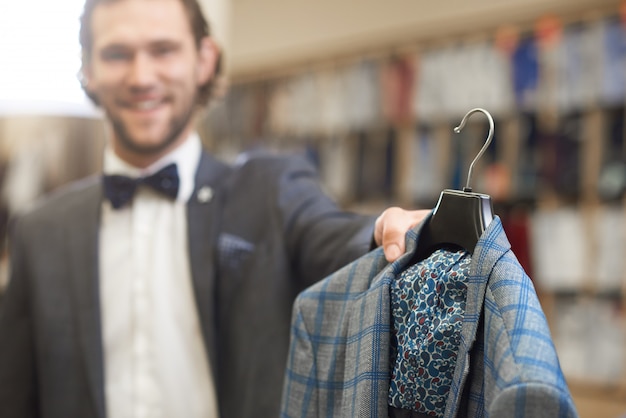 Homme élégant en costume avec noeud papillon dans le magasin de sexe masculin.