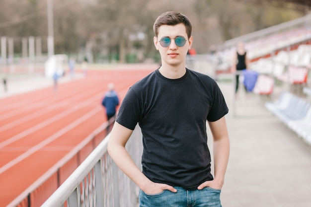 Un homme élégant dans un T-shirt noir. Photo de rue