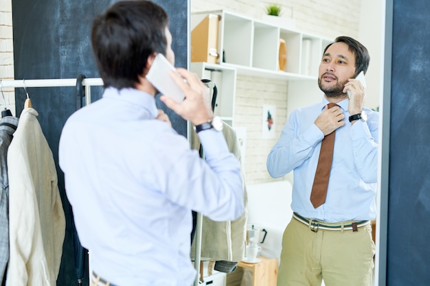 Homme élégant parlant au téléphone près de miroir