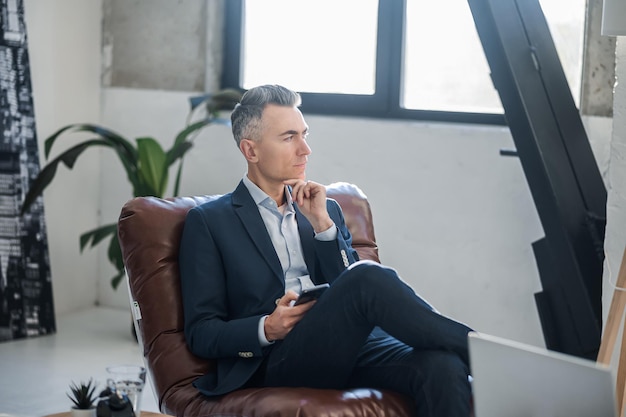 Homme élégant avec un smartphone dans les mains