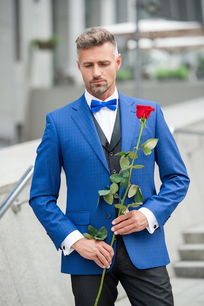 Photo homme élégant en smoking homme portant un smoking noeud papillon adulte en plein air homme smoking avec rose rouge