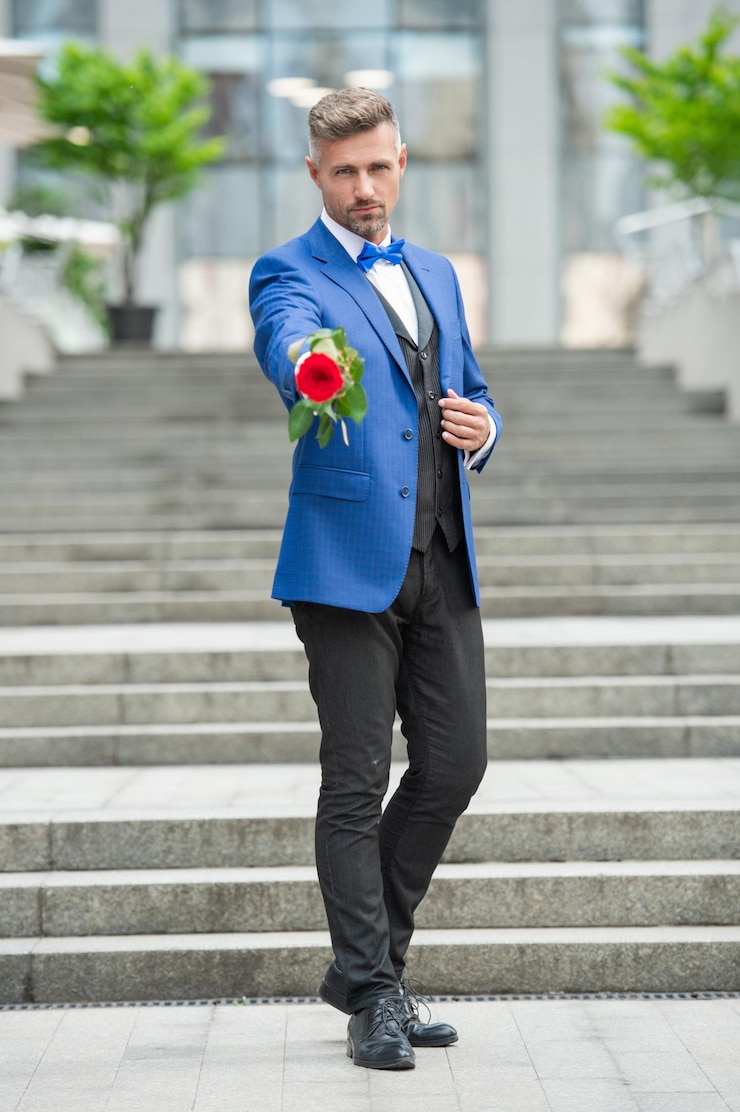 Photo un homme élégant en smoking pour une occasion romantique un homme avec un cadeau romantique un bel homme romantique avec une rose une attention sélective