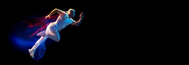 Homme élégant en tenue de sport blanche danse breakdance hiphop isolé sur fond sombre en néon mixte