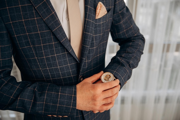 Homme élégant en veste avec cravate toucher la montre